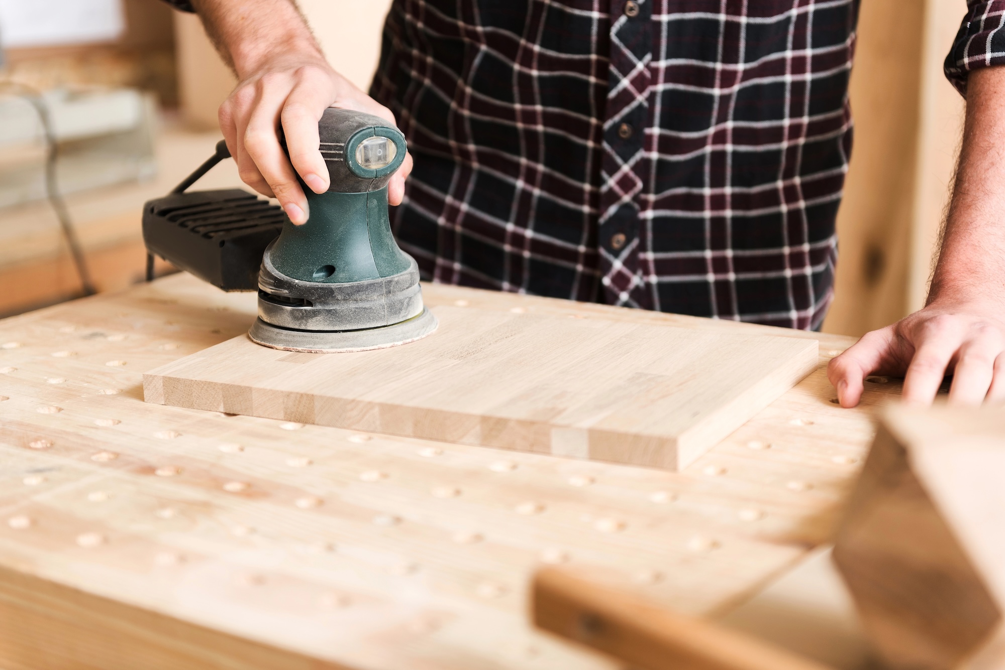Young carpenter is working in his workshop